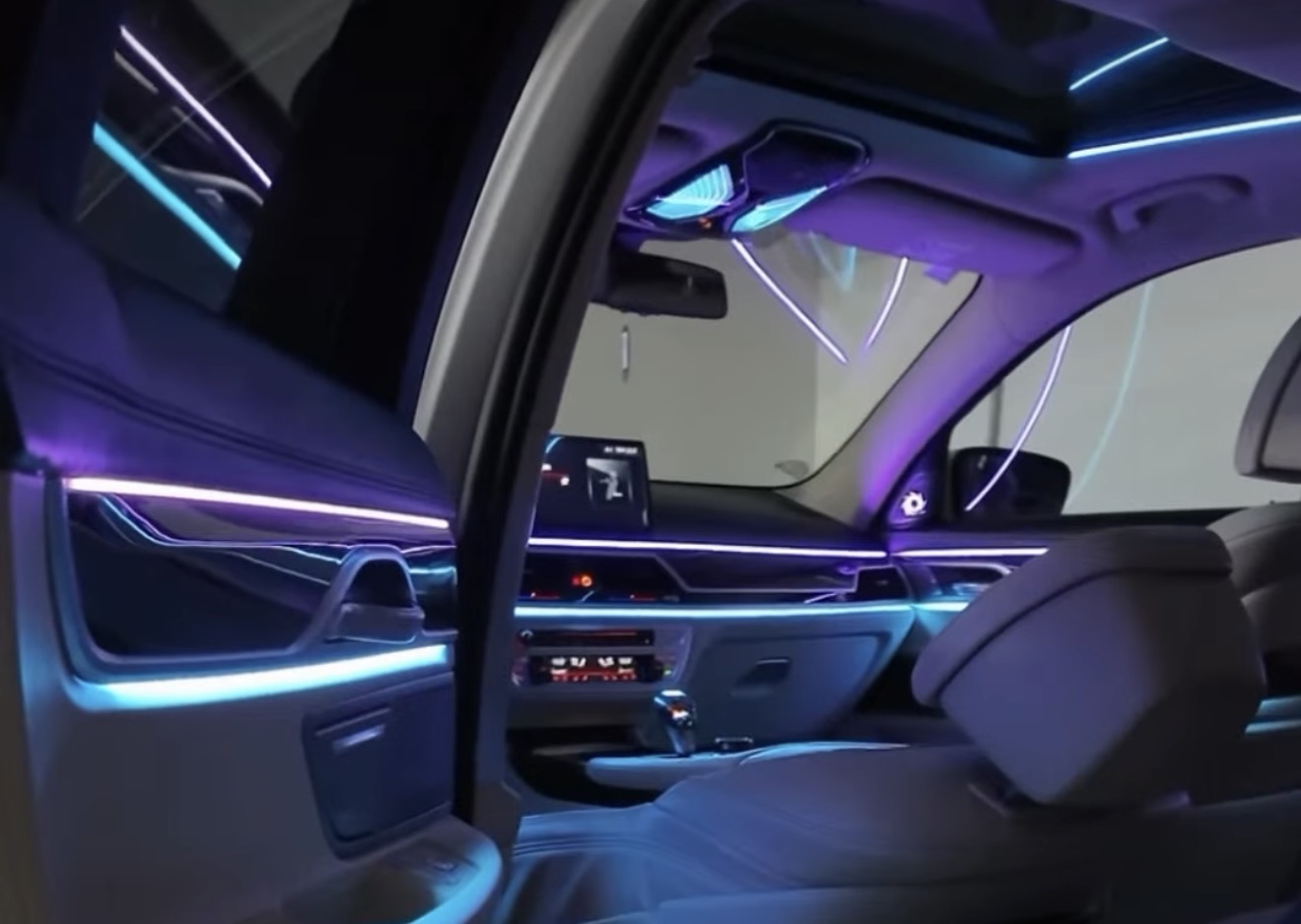 Blick aus dem Fond auf türkisfarbene und violette Lichtlinien im BMW G11